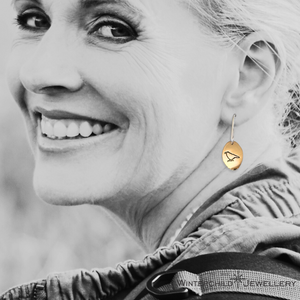 Model wearing raven sunrise oval earrings