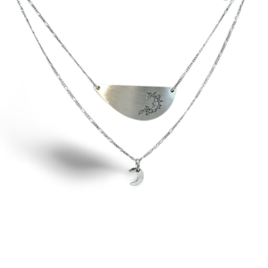 Layered silver necklace.  Top pendant has a harvest moon symbol on it and below hangs a mini crecent moon pendant.