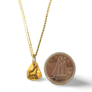 0.9 gr Wolf Gold Nugget Necklace beside a dime